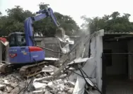 Proses pembongkaran bangunan mewah di lingkungan Lapas Kelas IIA Cibinong menggunakan alat berat.
